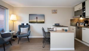 a kitchen with a table and chairs and a lighthouse at Sylter Rose in Westerland (Sylt) +12 photos