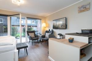 a kitchen and living room with a counter and chairs at Sylter Rose in Westerland (Sylt)