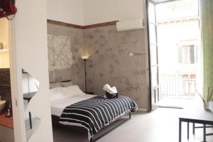 a bedroom with a bed with a black and white striped blanket at New Rubik's Castle in Catania