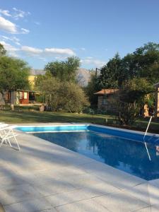 una piscina con una silla junto a una casa en Raco De La Calma en Nono