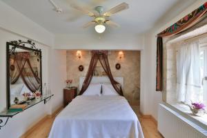 a bedroom with a bed with a ceiling fan at Stone Villa,Large Garden,Swimming Pool, Very Close the Beautiful Beach . in Cesme