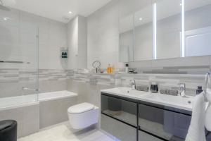 a white bathroom with a toilet and a sink at Massive 5 Bedroom West End Designer Residence close to popular Notting Hill in London