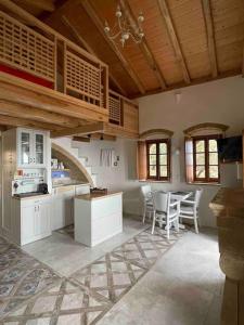 een keuken met witte kasten en een tafel en stoelen bij MONOVASIA SUITES Anopolis in Monemvasia