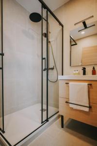 een badkamer met een douche en een glazen deur bij Apparts'hôtel l'Europe - centre gare- in Saint-Malo