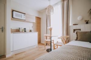 a bedroom with a bed and a table in a room at Apparts'hôtel l'Europe - centre gare- in Saint Malo