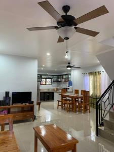 a living room with a ceiling fan and a dining room at Entire Island home with Starlink and gated parking in Dapa