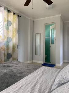 1 dormitorio con 1 cama y puerta al baño en Entire Island home with Starlink and gated parking, en Dapa