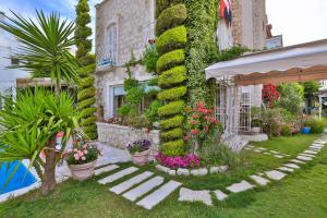 a garden with flowers and plants in front of a building at Stone Villa,Large Garden,Swimming Pool, Very Close the Beautiful Beach . in Cesme