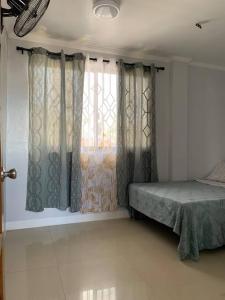 una camera con letto e finestra con tende di Entire Island home with Starlink and gated parking a Dapa