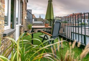 a balcony with a table and an umbrella at The Newport Lodge - incl Breakfast, 3u Wellness and Ebike in Nieuwpoort