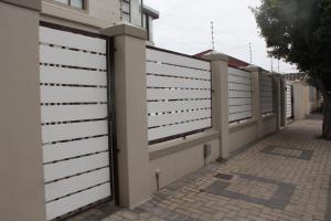 a fence with white panels on the side of a building at Goodwood Oasis Free WiFi-Parking 2 in Cape Town