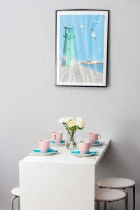 a white table with chairs and a picture of a lighthouse at Gdańsk Krasickiego Apartments by the Beach by Renters in Gdańsk