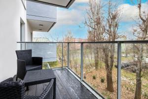 a balcony with a view of the woods at Gdańsk Krasickiego Apartments by the Beach by Renters in Gdańsk