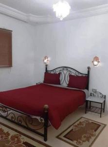 um quarto com uma cama grande e lençóis vermelhos em Diar Karim Djerba em Midoun