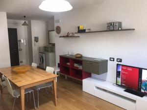 eine Küche und ein Esszimmer mit einem Tisch und einem TV in der Unterkunft Le Case del Ponte in Villa di Tirano