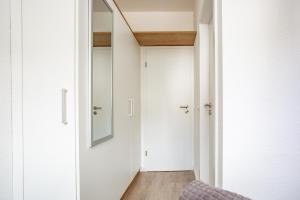 pasillo con puerta y espejo en boardinghouse44, en Georgsmarienhütte