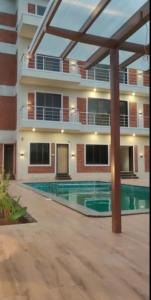 a building with a swimming pool in front of a building at Lotus The Lake View Resort in Alibaug