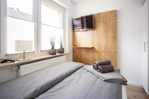 1 dormitorio con 1 cama y TV de pantalla plana en boardinghouse44, en Georgsmarienhütte
