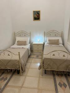 a bedroom with two beds and a dresser with a night stand at Palazzo Giannotte Suite & Spa in Ostuni