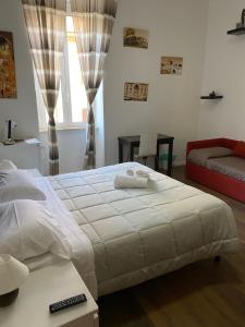 ローマにあるaffittacamere san pietro resortのベッドルーム(大きな白いベッド1台、ソファ付)