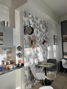 a kitchen with a table and a clock on a wall at Vieille tour Hotel centre Rouen in Rouen