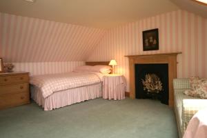 1 Schlafzimmer mit 2 Betten und einem Kamin in der Unterkunft Springburn Cottage in Strachur