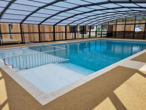 a large swimming pool with anolean at La cabane 27 ~ Chalet cosy au bord du lac de Peyre in Labouheyre