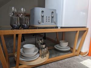 a table with plates and wine glasses and a microwave at *Large Unique Retro Private Attic & Bathroom* in Brighton & Hove