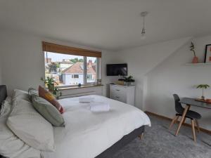 a bedroom with a bed and a desk and a window at *Large Unique Retro Private Attic & Bathroom* in Brighton & Hove