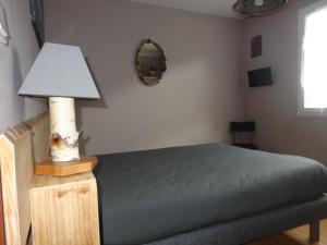 リュス・サン・ソヴァールにあるChez Corine Marque Bastampeのベッドルーム(ランプ、鏡付)