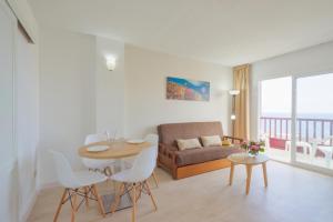 un soggiorno con tavolo, sedie e divano di Apartamentos Centro Cancajos a Los Cancajos