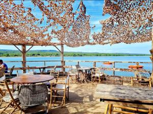 a patio with tables and chairs and a body of water at Duplex Climatisé 65m2 refait à neuf in Gruissan