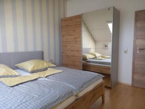 een slaapkamer met een bed en een grote spiegel bij Haus Oettinger in Hayingen