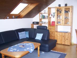 ein Wohnzimmer mit einem blauen Sofa und einem Couchtisch in der Unterkunft Haus Oettinger in Hayingen