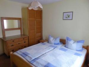 a bedroom with a large bed and a dresser at Ferienhof Selz in Haundorf