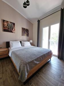- une chambre avec un grand lit et une grande fenêtre dans l'établissement Villa Peskena's, à Potamós