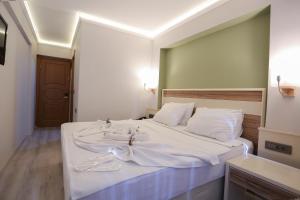 a bedroom with a large bed with white sheets at BEST SMYRNA HOTEL in Aydın