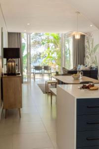 a kitchen and living room with a couch and a table at Newly renovated stylish Mallorca Apartment in Umdloti