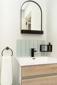 a bathroom with a sink and a mirror at Newly renovated stylish Mallorca Apartment in Umdloti