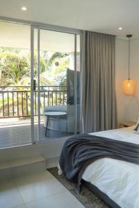 una camera con letto e balcone di Newly renovated stylish Mallorca Apartment a Umdloti
