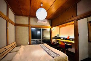青梅市にある加美屋リゾート奥多摩 テラス & 風呂-Kamiya Resort Okutamaのベッドルーム1室(ベッド1台、デスク付)