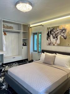 a bedroom with a bed with a painting of horses on the wall at Aesthesis Arxontiko Luxury Rooms in Mirina