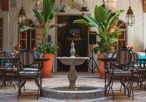 a group of chairs and a fountain in a courtyard at Riad Al Madina in Essaouira