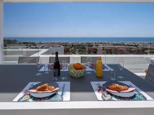 einen Tisch mit zwei Teller mit Speisen und Weingläsern in der Unterkunft Magnificent penthouse with panoramics views in Casares
