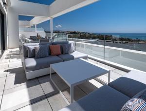 ein Wohnzimmer mit einem Sofa und einem Tisch auf dem Balkon in der Unterkunft Magnificent penthouse with panoramics views in Casares