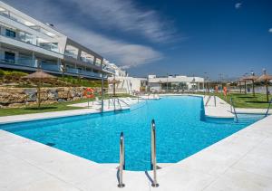einem Pool vor einem großen Gebäude in der Unterkunft Magnificent penthouse with panoramics views in Casares