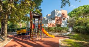 un parque infantil con un tobogán frente a un edificio en Résidence Pierre & Vacances Les Terrasses Du Parc, en La Grande-Motte