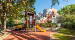 a playground with a slide in front of a building at Résidence Pierre & Vacances Les Terrasses Du Parc in La Grande Motte