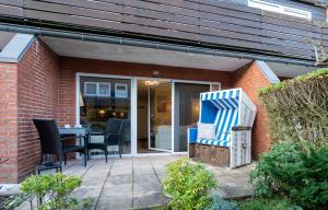 a patio with chairs and a table in front of a building at Sylter Rose in Westerland (Sylt)
