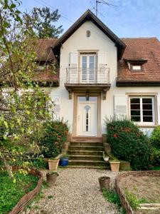a white house with stairs and a balcony at Authenticité et Sérénité in Obernai